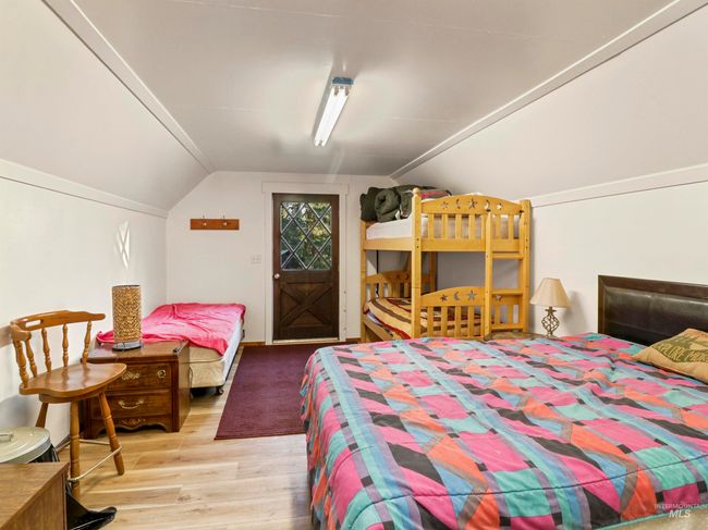 Bedroom with vaulted ceiling and wood finished floors | Image 42