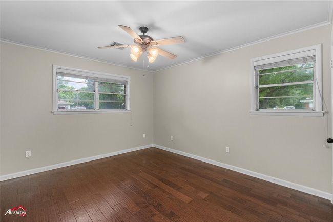 Spare room featuring dark wood-type flooring, a ceiling fan, baseboards, and ornamental molding | Image 15