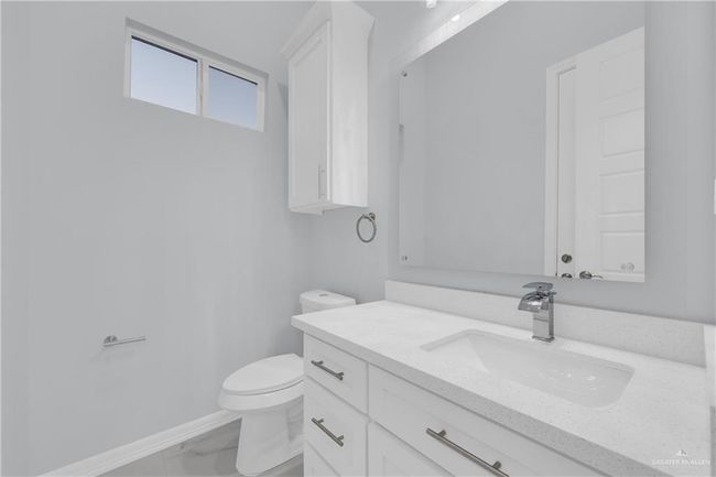 Bathroom with toilet, marble finish floor, baseboards, and vanity | Image 19