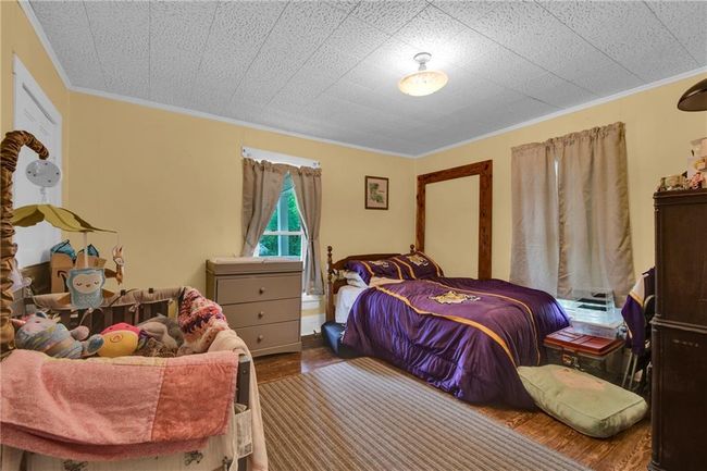 Bedroom with ornamental molding and wood finished floors | Image 12