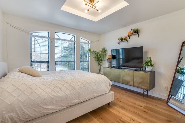 Bedroom featuring a chandelier, a raised ceiling, baseboards, and light wood finished floors | Image 27