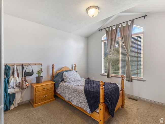 Bedroom featuring carpet, lofted ceiling, and baseboards | Image 24