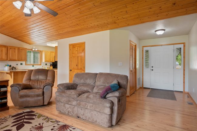 Living area featuring light wood-style flooring, ceiling fan, and wooden ceiling | Image 18