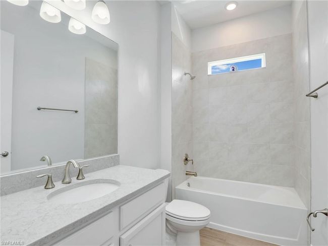 Full bathroom with vanity, toilet, wood-type flooring, and tiled shower / bath | Image 31