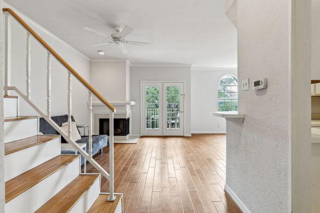 An inviting entry into the home with tall ceilings and wall to wall wood flooring. | Image 7