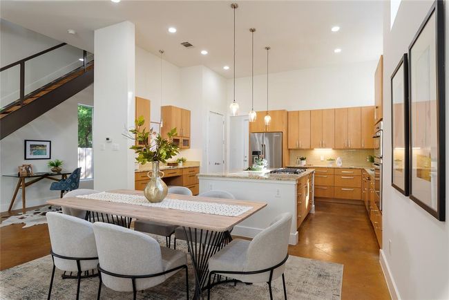 Dining area featuring a towering ceiling, recessed lighting, concrete flooring, and baseboards | Image 11