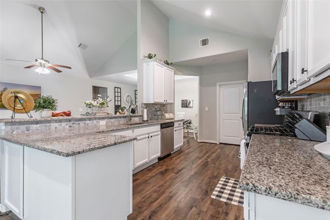Tasteful backsplash and granite countertops. | Image 16