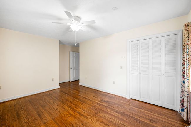 Unfurnished bedroom featuring baseboards, wood finished floors, and ceiling fan | Image 24