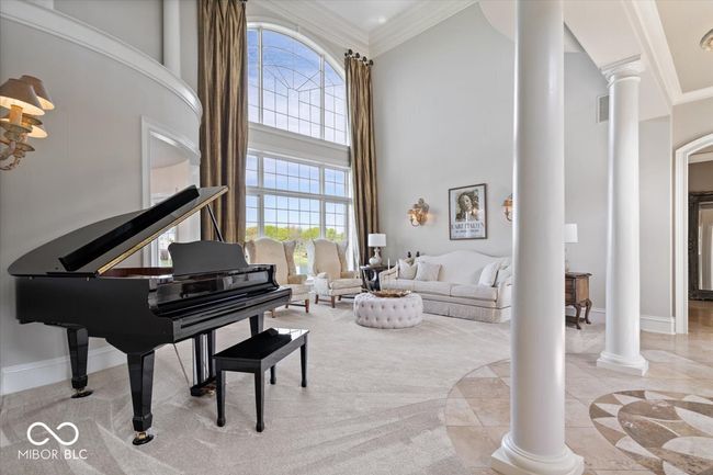 2-story living room flooded with natural light by floor-to-ceiling windows. | Image 11