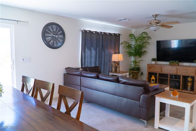 Living area featuring carpet floors, visible vents, and a ceiling fan | Image 30