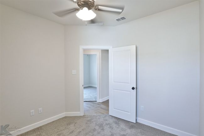 Carpeted empty room featuring a ceiling fan and a smoke detector | Image 19