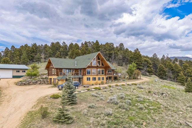 Rear view of house with driveway and a forest view | Image 8