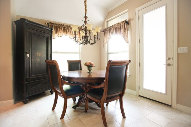 Breakfast area featuring a chandelier and baseboards. | Image 5