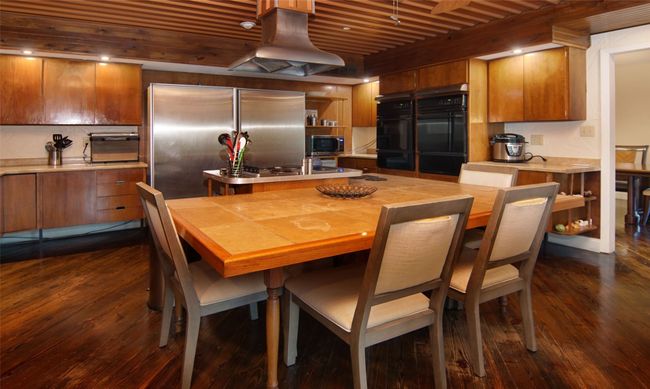 Authentic retro cabinets, oversized breakfast bar, built-in cooktop, double ovens, huge sub-zero fridge & freezer, recessed lighting, and more of the copper ceiling! | Image 11