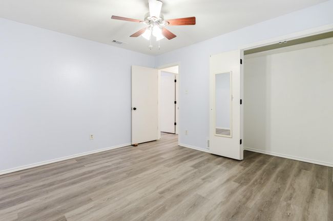 Unfurnished bedroom with baseboards, visible vents, light wood-style flooring, and a ceiling fan | Image 13