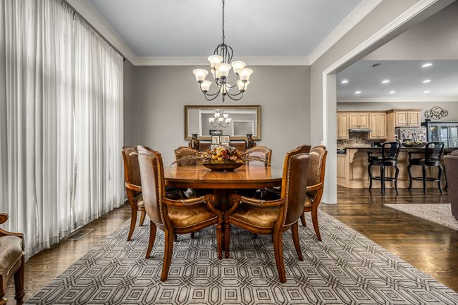 A dining room with 10-foot ceilings offers a grand ambiance, ideal for formal gatherings. Its openness to the kitchen and family room ensures a seamless flow, perfect for socializing and entertaining. | Image 31