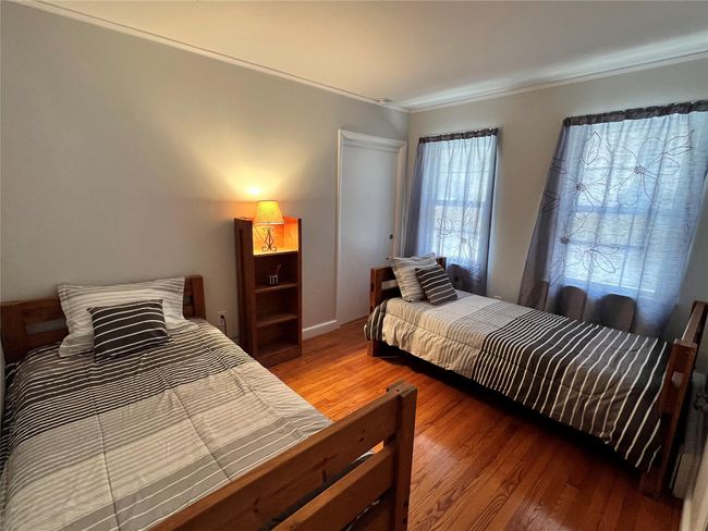 Bedroom with wood finished floors and crown molding | Image 45