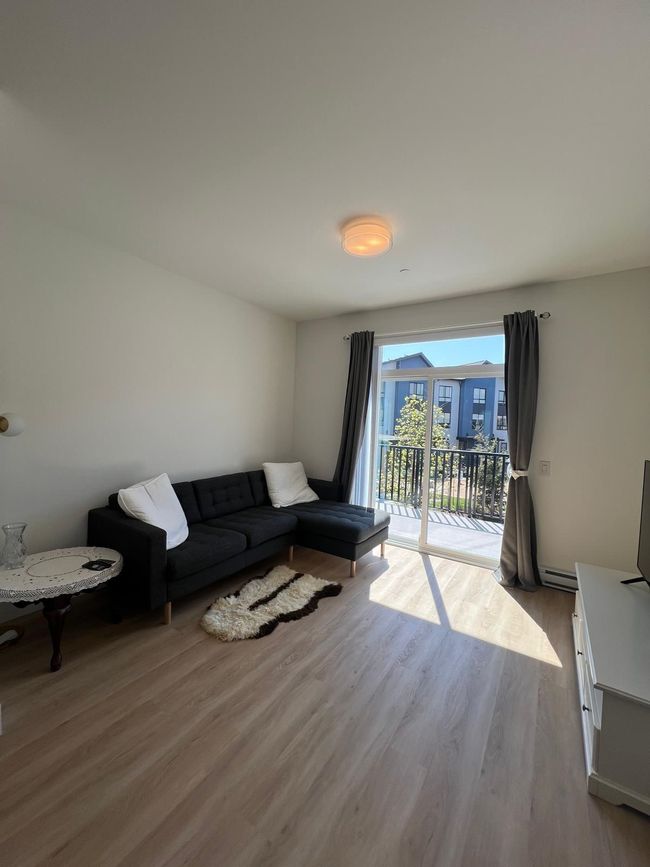 Living area featuring wood finished floors and a baseboard heating unit | Image 4
