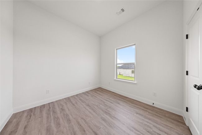 Empty room featuring vaulted ceiling, wood finished floors, and baseboards | Image 9