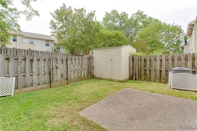 Fenced backyard with a storage shed and a patio area | Image 16
