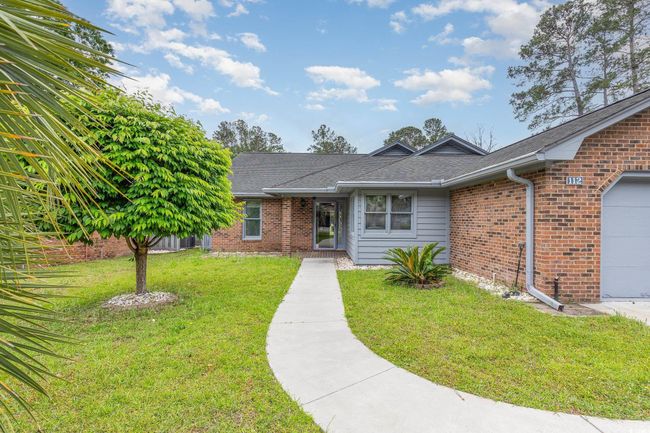 Single story home with an attached garage, a front lawn, brick siding, and roof with shingles | Image 5