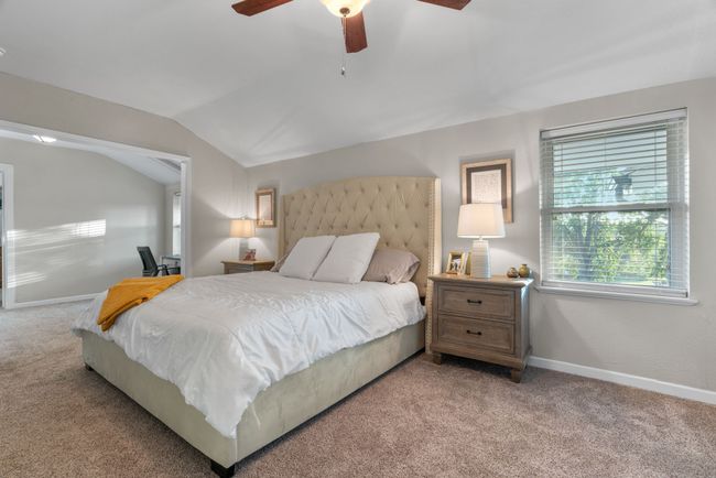 Bedroom featuring light colored carpet, vaulted ceiling, and a ceiling fan | Image 23
