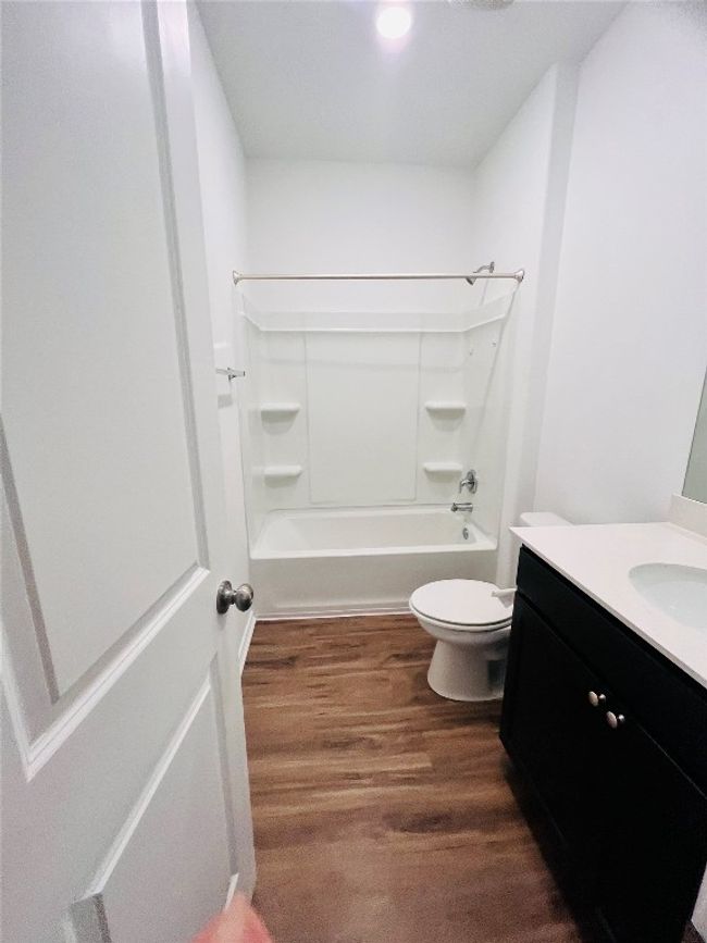 Bathroom with vanity, wood finished floors, bathing tub / shower combination, and recessed lighting | Image 7
