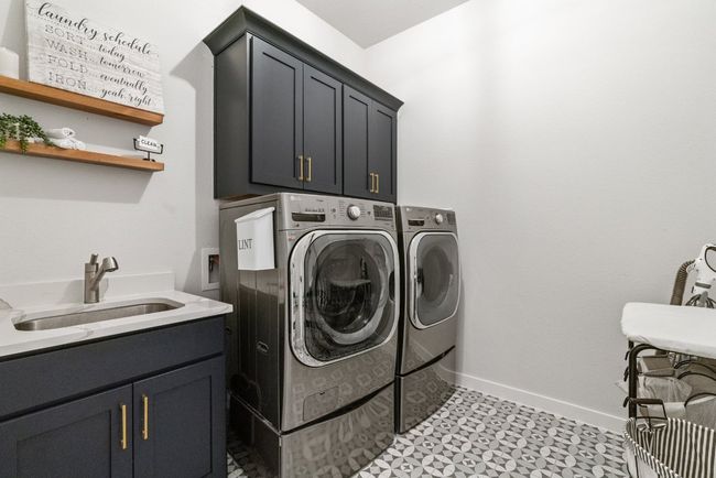 Laundry area with cabinet space, washing machine and dryer, and light flooring | Image 30