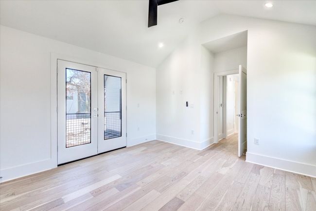 The primary bedroom features vaulted ceilings and a Juliet balcony with French doors that open to the yard/courtyard below. White oak flooring throughout the home - no carpet! SEE VIRTUAL TOUR LINK WITH INTERACTIVE FLOOR PLAN AND 3D WALK THRU. | Image 20