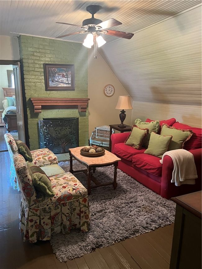 Living room with a fireplace, a ceiling fan, hardwood / wood-style flooring, and lofted ceiling | Image 15