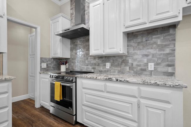 More storage and an electric range in the kitchen. | Image 16