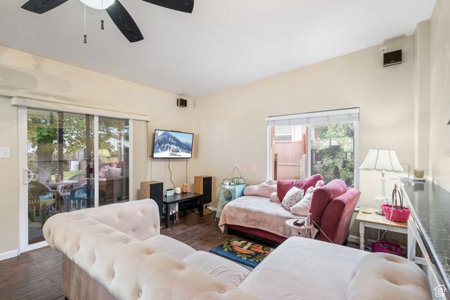 Living room with a ceiling fan and dark wood-type flooring | Image 5