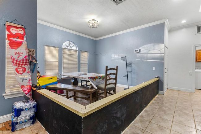 Tiled dining space featuring ornamental molding and washer / dryer | Image 9