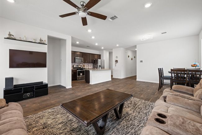 Living area featuring a ceiling fan, dark wood-type flooring, baseboards, and recessed lighting | Image 9