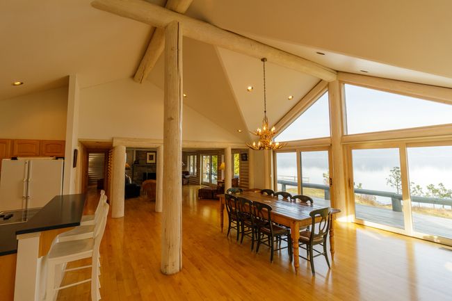 Dining area featuring plenty of natural light, beam ceiling, high vaulted ceiling, and a chandelier | Image 20