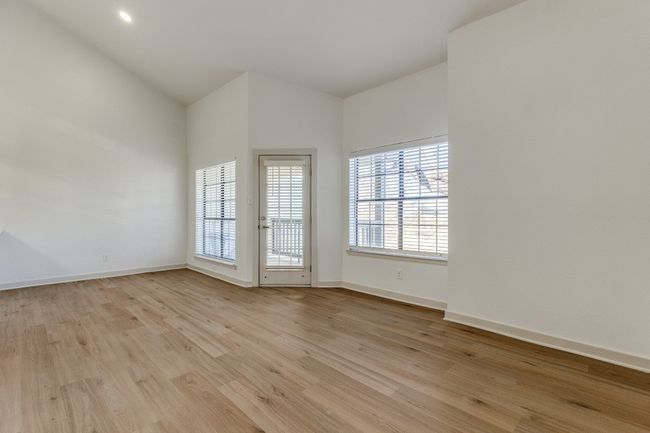 Spare room featuring light hardwood / wood-style floors and high vaulted ceiling | Image 27