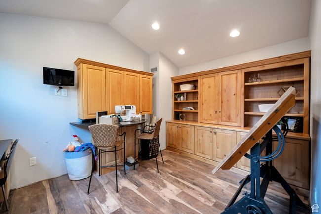 Office featuring recessed lighting, light wood-type flooring, visible vents, built in study area, and lofted ceiling | Image 35