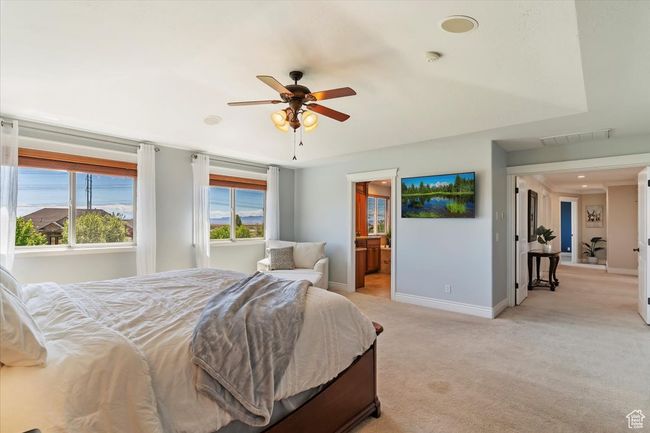 Bedroom with baseboards, visible vents, ensuite bath, and light colored carpet | Image 34