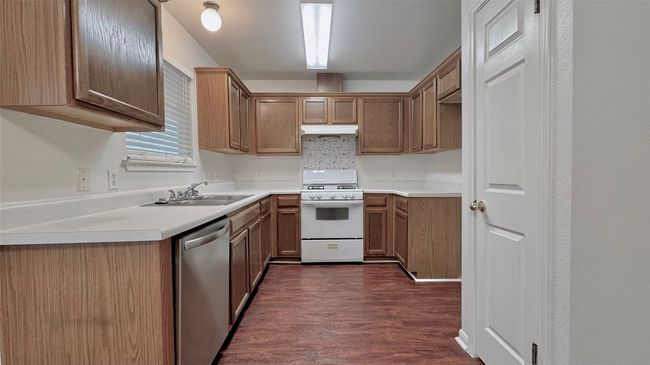 Kitchen with gas range gas stove, dishwasher, dark wood-style floors, light countertops, and separate pantry | Image 8