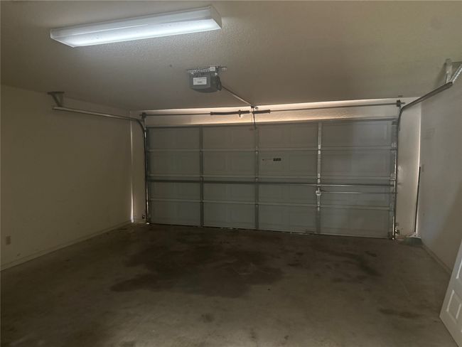 Garage with a garage door opener and baseboards | Image 23