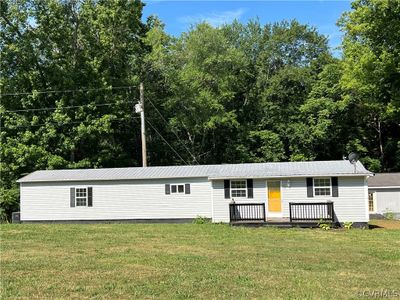 View of front of home with a front yard and a deck | Image 1