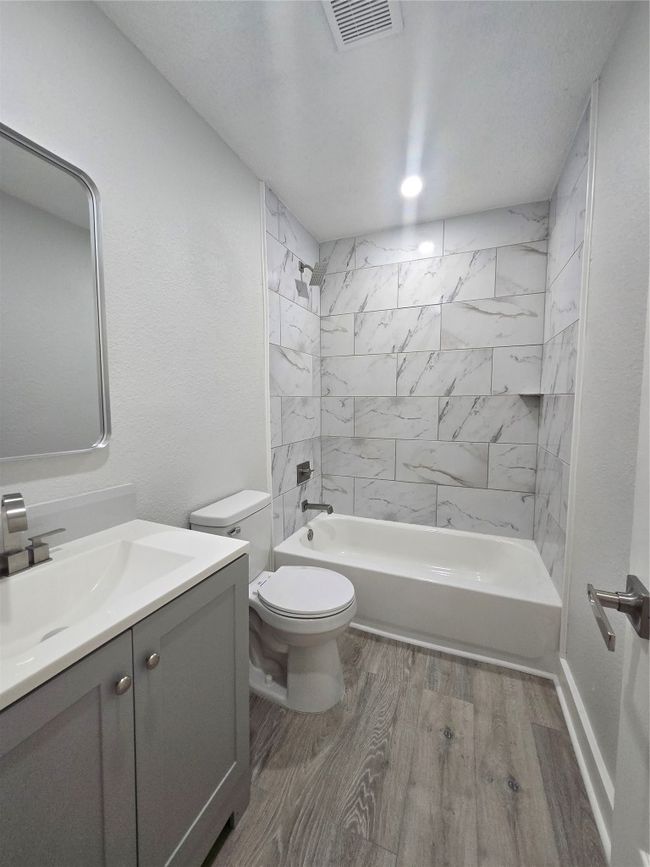 Full bathroom featuring vanity, wood finished floors, and bathing tub / shower combination | Image 14