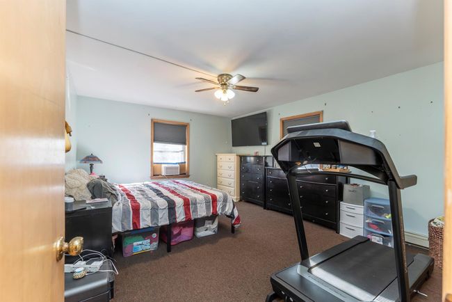 Carpeted bedroom featuring cooling unit and ceiling fan | Image 34