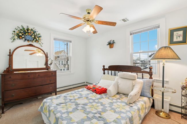 Carpeted bedroom with a baseboard radiator and ceiling fan | Image 17