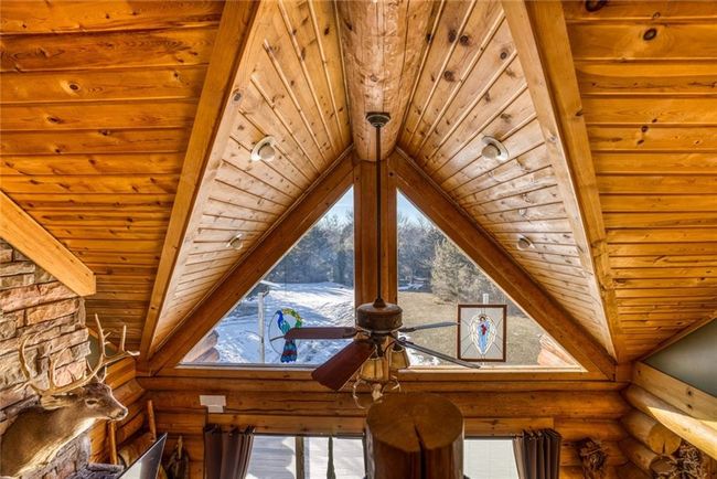 Interior details with a ceiling fan, beam ceiling, wood ceiling, and log walls | Image 11