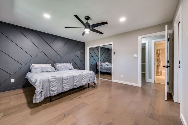 Bedroom featuring a closet, wood finished floors, an accent wall, recessed lighting, and a decorative wall | Image 16