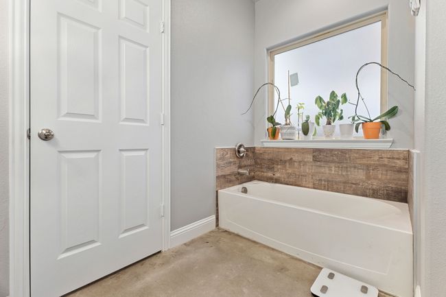 Bathroom with concrete flooring and a tub to relax in | Image 19