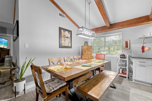 Dining space featuring visible vents, lofted ceiling with beams, and light wood-style flooring | Image 12