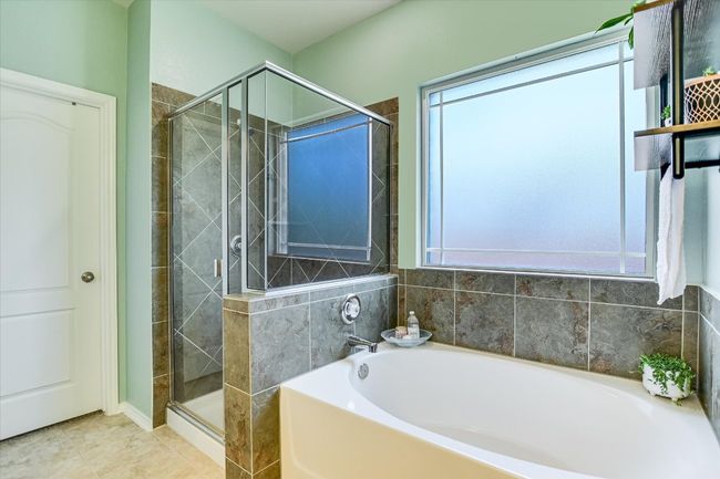 Bathroom with a garden tub, healthy amount of natural light, and a stall shower | Image 15