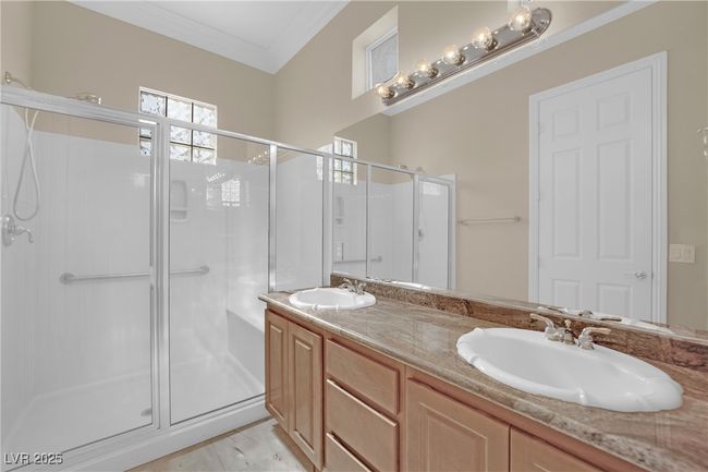 Bathroom featuring a sink, double vanity, a stall shower, and crown molding | Image 30
